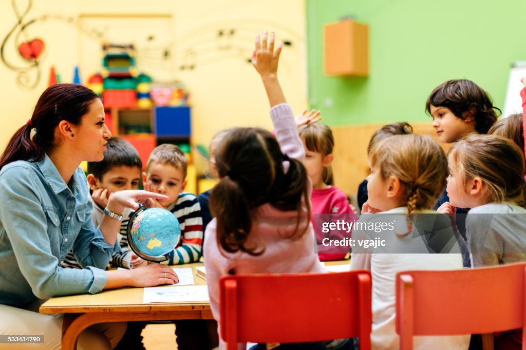 Preschool teacher and children in classroom