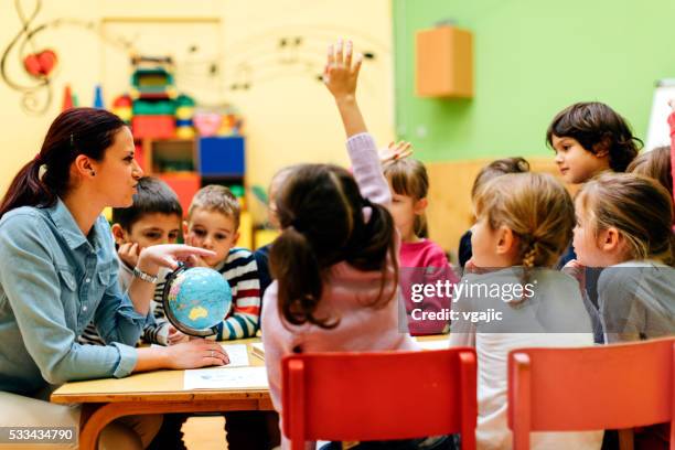 preschool teacher and children in classroom - child listening differential focus stock pictures, royalty-free photos & images