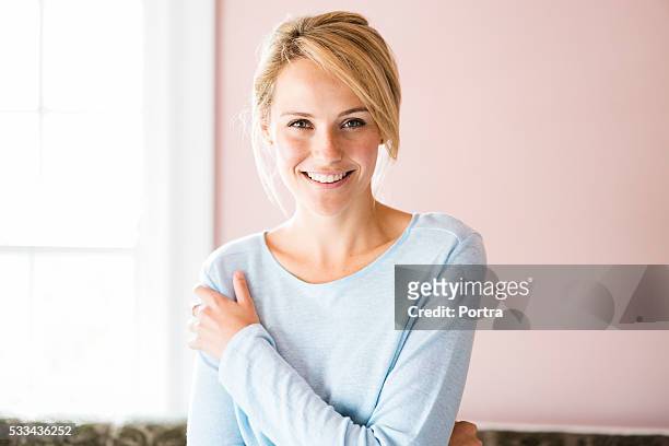 portrait of smiling young woman at home - beautiful blondes stockfoto's en -beelden
