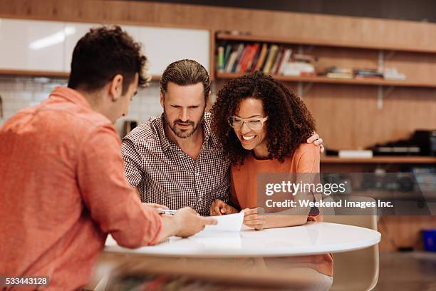 couple signing a contract - signing mortgage stock pictures, royalty-free photos & images