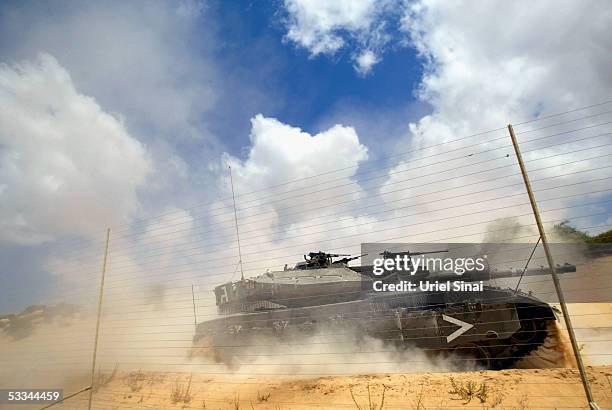 An Israeli army Merkava tank patrols alongside a security fence as they search for Palestinian gunmen during an infiltration alert on August 9, 2005...