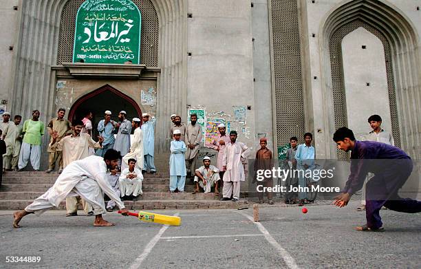 Madrassa students play a game of street cricket in front of their school after class on August 4, 2005 in Multan, Pakistan. The Pakistani government...