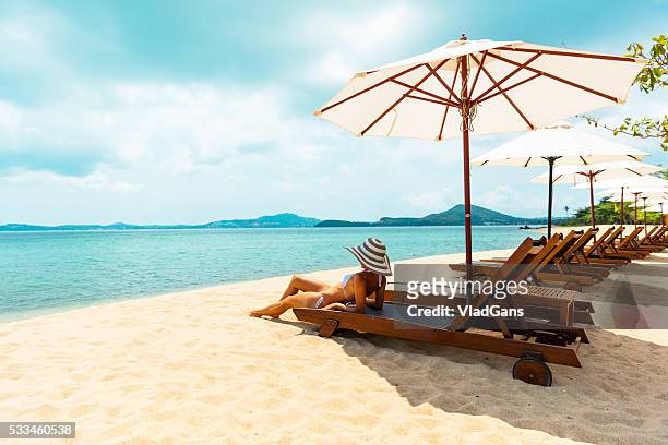 frau sonnenbaden im strand-stuhl - beach holiday stock-fotos und bilder