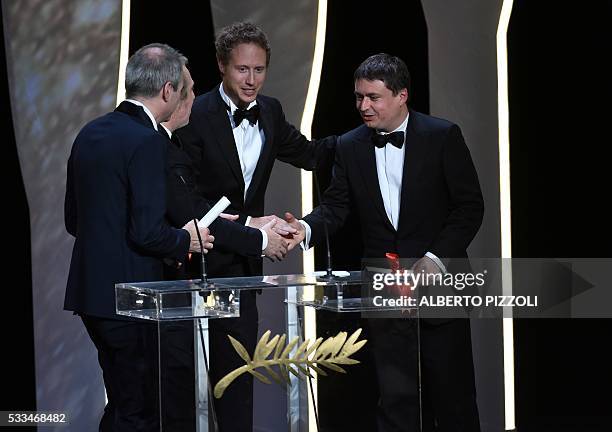 French director Olivier Assayas and Romanian director Cristian Mungiu arrive on stage to both receive from French director and member of the Jury...