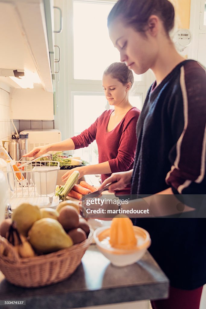 Zwei junge Frau, die Zubereitung von Speisen in der Küche Schrank.