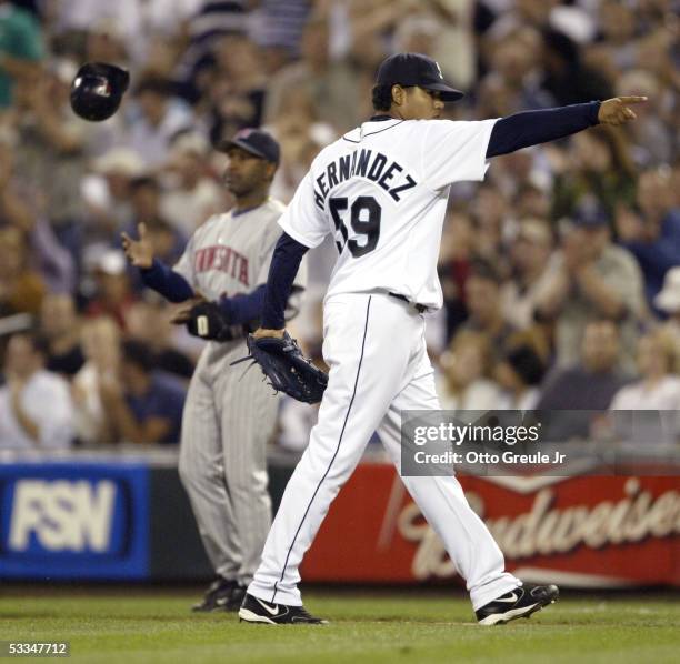 Starting Pitcher Felix Hernandez of the Seattle Mariners points to the dugout after Nick Punto of the Minnesota Twins made the last out of the eighth...