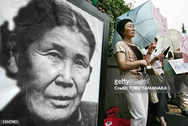 People stands beside a portrait of late comfort woman Kim Hak-Sun of South Korea during a demonstration in front of the national parliament in Tokyo,...