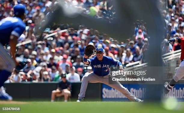 Justin Smoak of the Toronto Blue Jays fields a throw from Josh Donaldson at third base to get Brian Dozier of the Minnesota Twins out at first base...