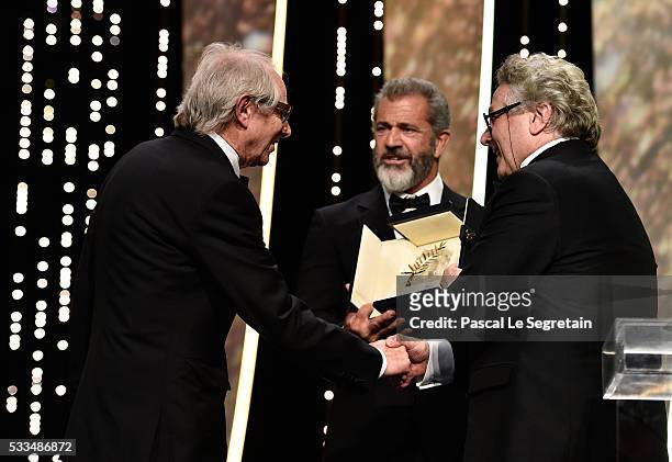 Director Ken Loach is congratulated by Mel Gibson and director and President of the Jury George Miller after being awarded the Palme d'Or for the...
