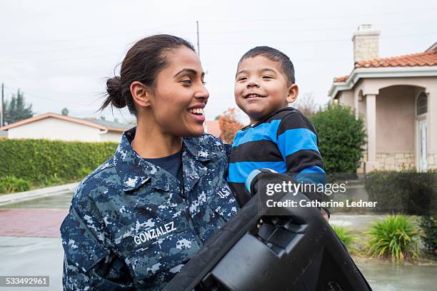 navy mom carrying young son - marine camouflage stockfoto's en -beelden