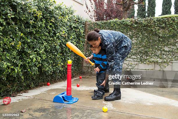 navy woman teaching young son tball - baseball mom stockfoto's en -beelden