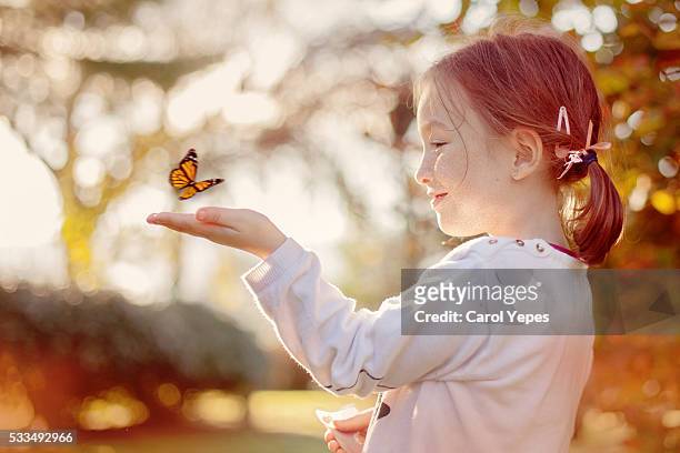girl releasing a butterfly - butterfly effect stockfoto's en -beelden