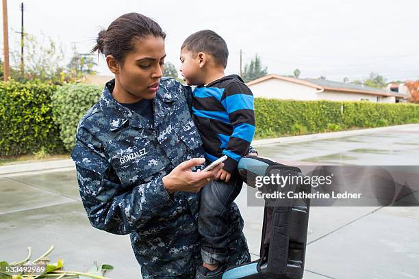 navy mom with phone and car seat - genderblend2015 stock pictures, royalty-free photos & images