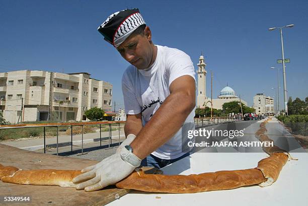 Palestinian baker presents a 750-meter-long baguette bread with the hope of entering the Guinness book of records in the West Bank city of Jenin, 10...