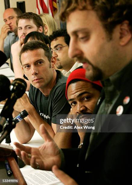 Scott Goodstein of Catalyst Campaigns speaks as musicians Head Roc and Eric Hilton of Thievery Corporation, look on during a news conference on...