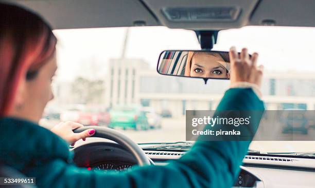 adjusting the rear view mirror - woman rear view mirror stock pictures, royalty-free photos & images