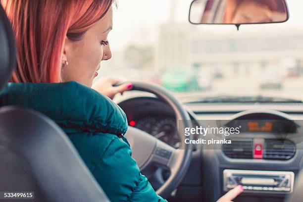 young driver changing radio stations - radio station stock pictures, royalty-free photos & images