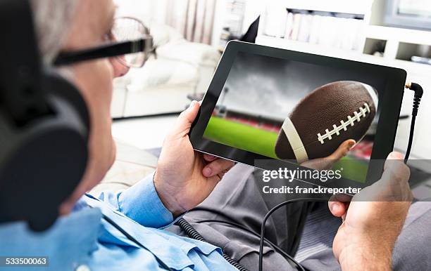 man watching a football game on the tablet - american football on screen bildbanksfoton och bilder