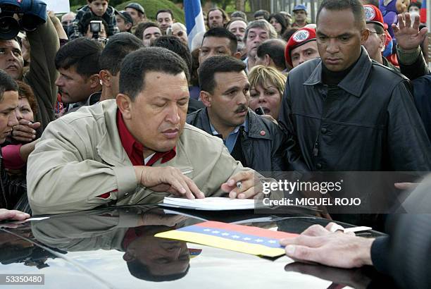 El presidente venezolano Hugo Chavez firma autografos luego de visitar la refineria estatal Ancap, en Montevideo, el 10 de agosto de 2005. Chavez...