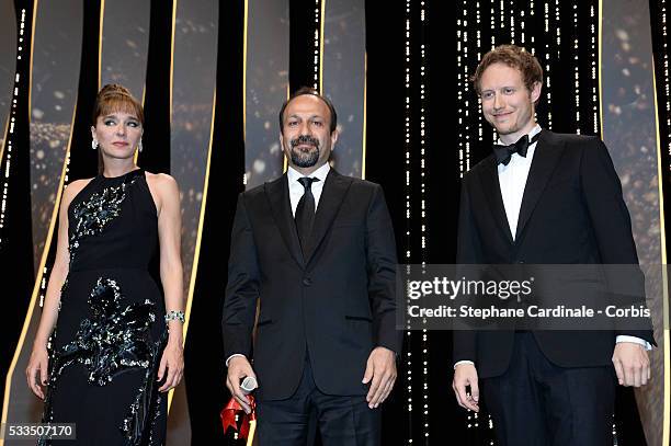 Iranian director Asghar Farhadi celebrates on stage with Valeria Golino and Laszlo Nemes after being awarded with the Best Screenplay prize for the...