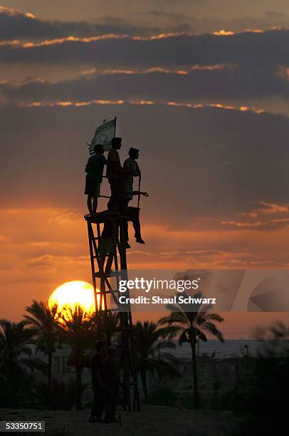 Israel settler teens stand on a small tower during sunset August 10, 2005 just outside the settlement of Neve Dekalim in the Gush Katif settlements...