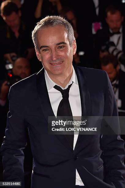 French director Olivier Assayas poses with his trophy during a photocall after he was awarded with the Best Director prize for the film "Personal...
