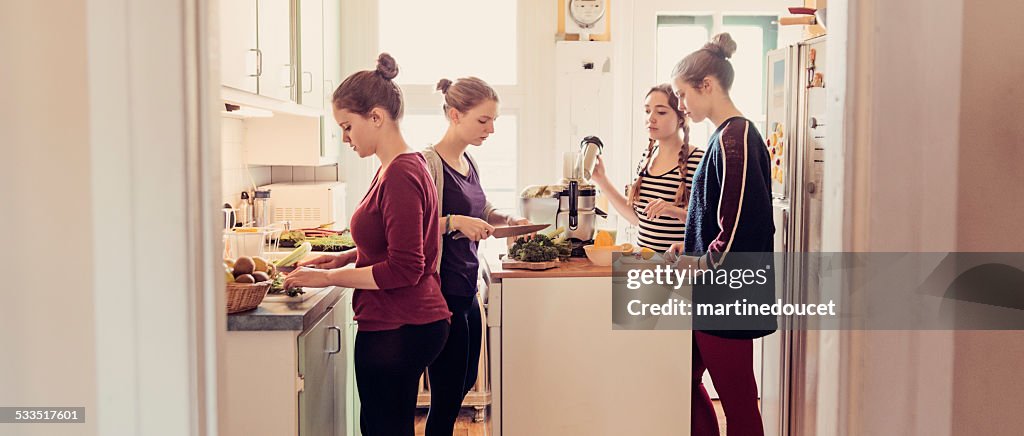 Quatre les collocatrices utilisez un presse-citron dans leur appartement cuisine.