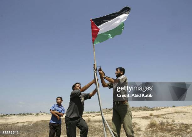 Palestinian Fatah activists place a Palestinian flag in front the Jewish settlement of Rafiah Yam during early celebrations of Israel's imminent pull...