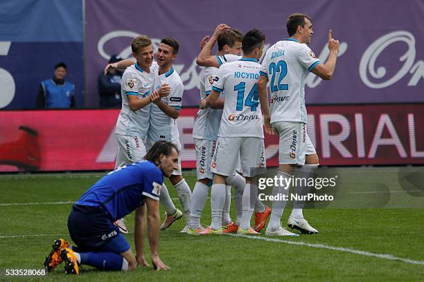 Vitali Dyakov of FC Dynamo Moscow reacts as Artem Dzyuba of FC Zenit St. Petersburg celebrates his goal with teammates during the Russian Football...