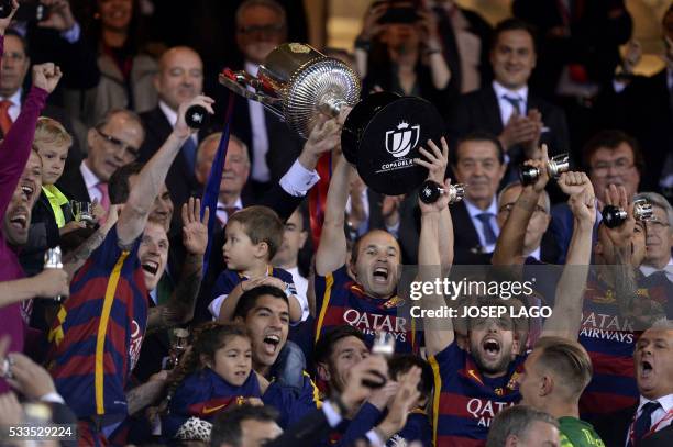 Barcelona's midfielder Andres Iniesta celebrates with the trophy after winning the Spanish "Copa del Rey" final match FC Barcelona vs Sevilla FC at...