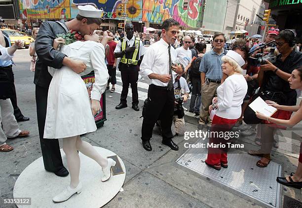 Eighty six-year-old Edith Shain stands in Times Square beside a statue of her famous kiss with a sailor on V-J Day at the end of World War II August...