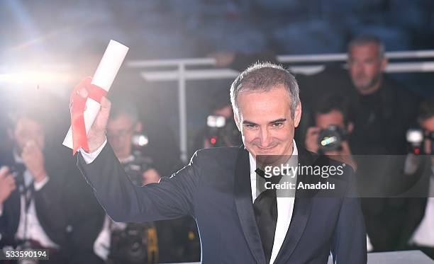 French director Olivier Assayas poses as the Best Director Award for his movie 'Personal Shopper' during the Award Winners photocall at the 69th...
