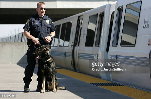 Bay Area Rapid Transit police officer Jason Ledford patrols with his bomb-sniffing dog Andy at the Oakland Coliseum station August 11, 2005 in...