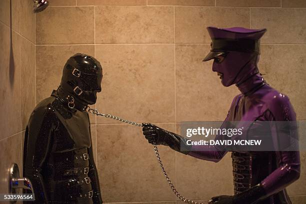 Rubber Lynn is dominated by Jenna Latex in a shower at a dungeon party during the DomCon LA domination convention on May 22, 2016 in Los Angeles,...
