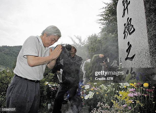 Japan Airlines President Toshiyuki Shinmachi offers prayers before a tomb stone for the victims of the 1985 JAL jetliner crash at Uneo village, 150km...