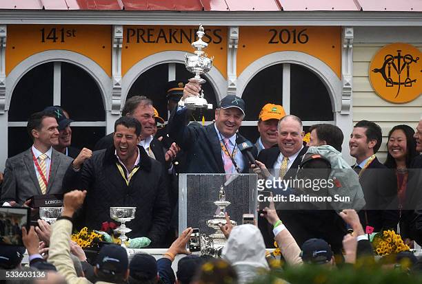 Owner Matt Bryan holds the Woodlawn Vase aloft after Exaggerator wins the 141st Preakness Stakes on Saturday, May 21 at Pimlico Race Course in...