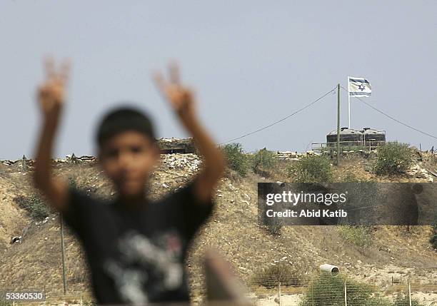 Palestinian boy gestures in front the Jewish settlement of Rafiah Yam during early celebrations of Israel's imminent pull out from Gaza, August 11 in...