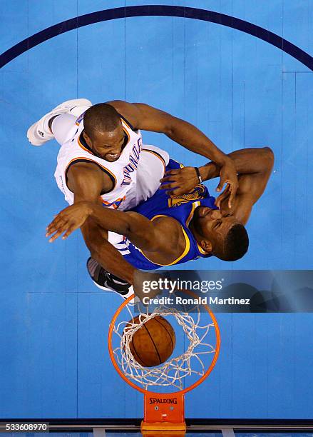 Serge Ibaka of the Oklahoma City Thunder dunks against Festus Ezeli of the Golden State Warriors in the first half in game three of the Western...