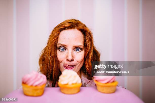 young woman really wants to eat cupcakes - lust stockfoto's en -beelden