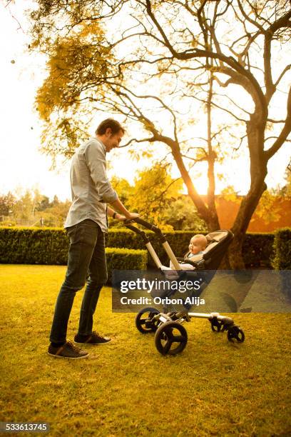 man walking with baby stroller - prams stock pictures, royalty-free photos & images