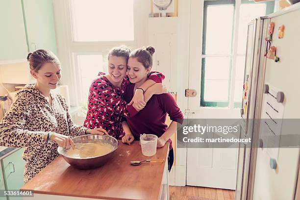 roommates wearing onesies making pancakes in kitchen, morning. - sparkdräkt bildbanksfoton och bilder