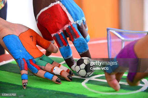 Students use their painted fingers to play kick soccer during a competition at Liaocheng University on May 22, 2016 in Liaocheng, Shandong Province...