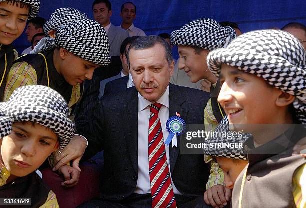 Turkish Prime Minister Recep Tayyip Erdogan poses with children wearing traditional clothes during his visit the southeastern city of Diyarbakir, 12...