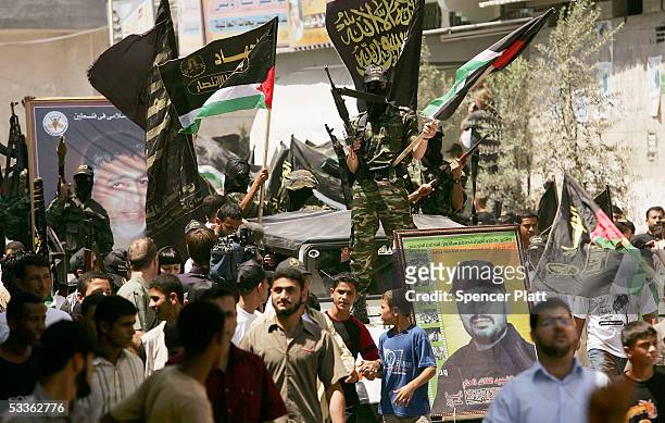 Members of the Palestinian group Islamic Jihad display weapons while walking through the streets in a march with supporters August 12, 2005 Gaza...