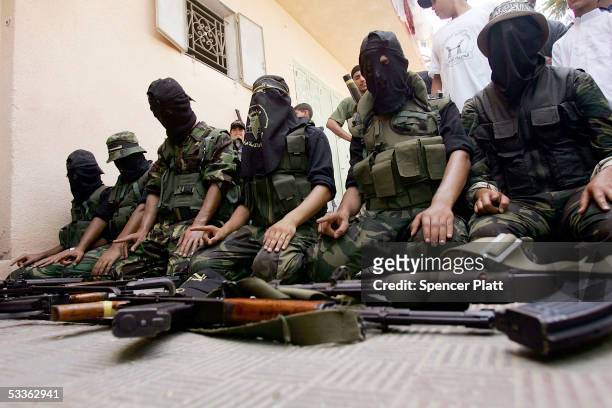 Members of the controversial Palestinian group Islamic Jihad display weapons while praying before walking through the streets in a march with...