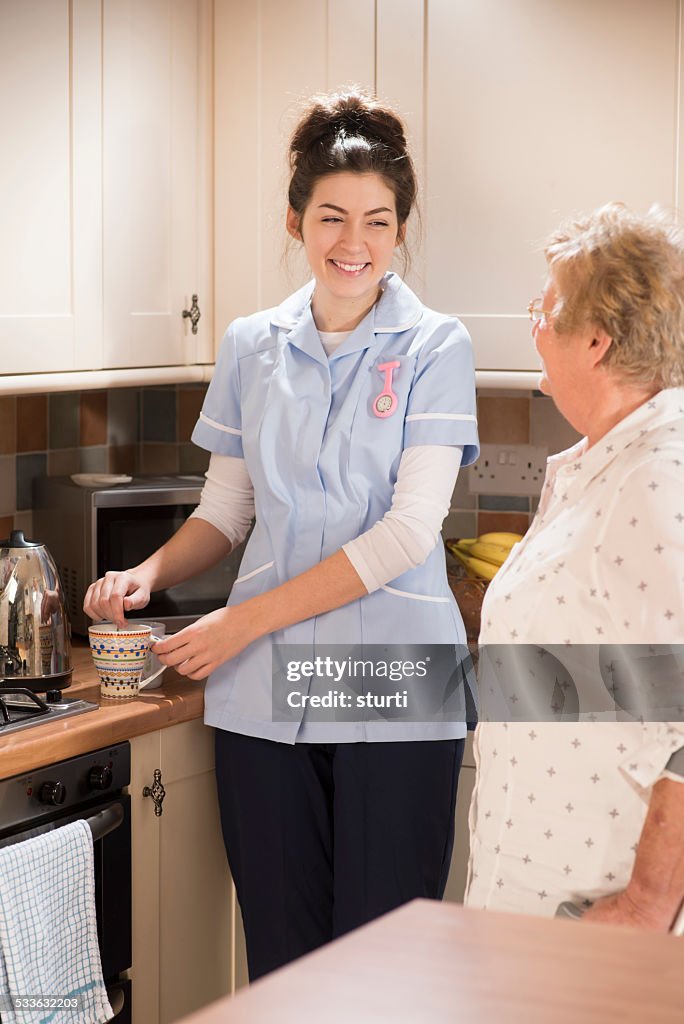 Senior woman chats to care worker