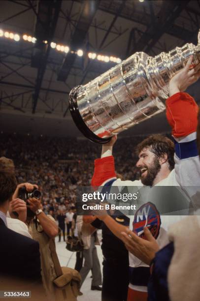 Canadian professional hockey player Clark Gillies of the New York Islanders holds the Stanley Cup over his head during celebrations after the...