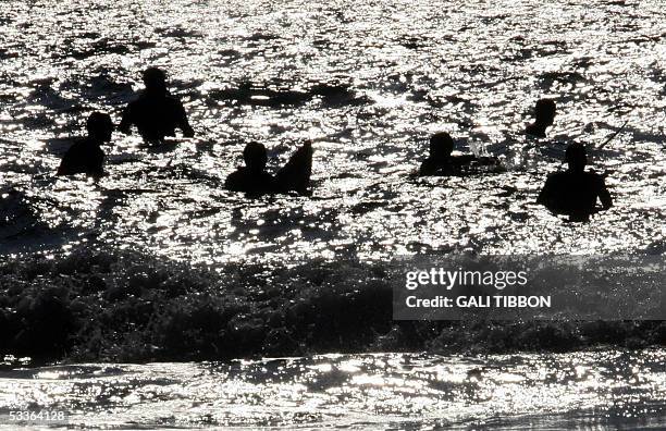Three days prior to Israel's upcoming disengagement plan from the Gaza Strip, Israeli settler surfers wait to catch a wave at the Palm beach near the...