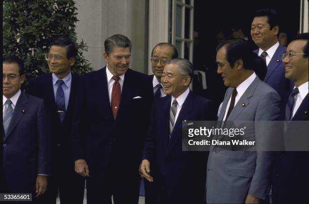 President Ronald with Reagan standing with visiting Japanese Prime Minister Noboru Takeshita and members of the Japanese Diet.