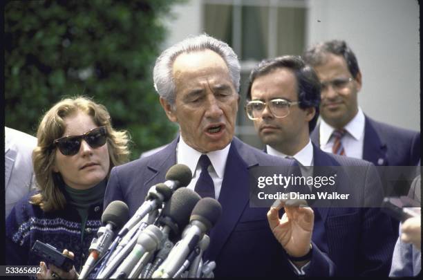 Israeli Foreign Minister Shimon Peres talking to press outside White House after meeting with President Ronald with Reagan; Peres' advisers Uri Savir...